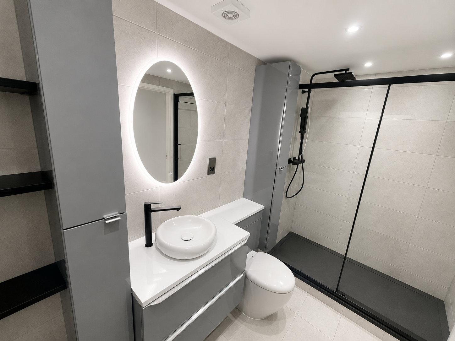 Acton bathroom showing the vanity, toilet and black-framed walk-in shower.