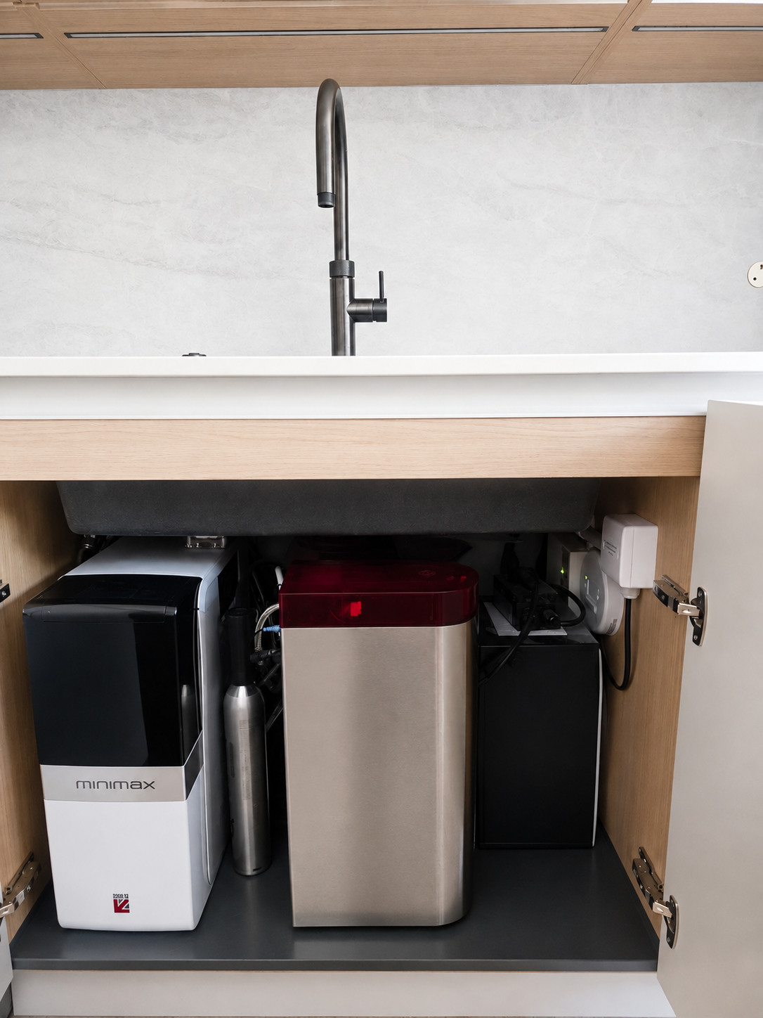 Kitchen sink with plumbing and appliances neatly arranged inside the cabinet below.