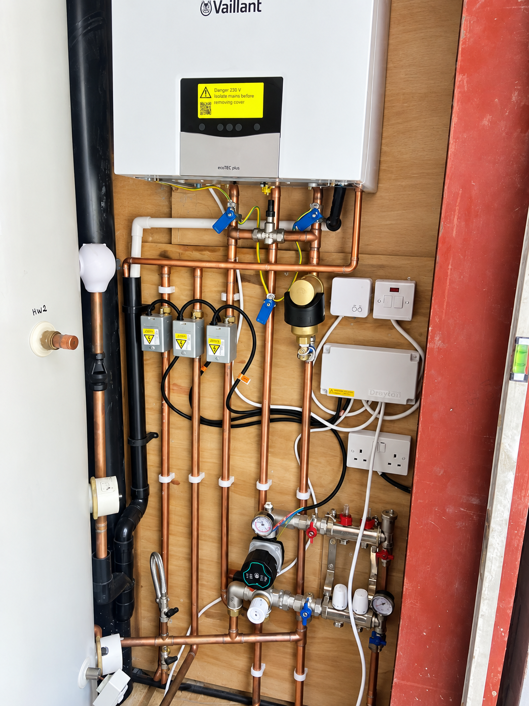 Close view of a Vaillant boiler, copper pipework, valves, electrical controls and heating components.