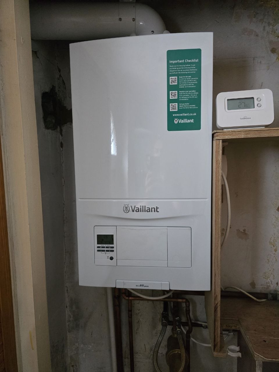 New Vaillant ecoFIT pure boiler installed inside a cupboard with pipework below.