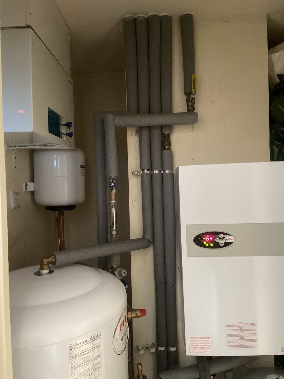 Close view of insulated heating pipework, expansion vessel and EHC Neptune cylinder beside